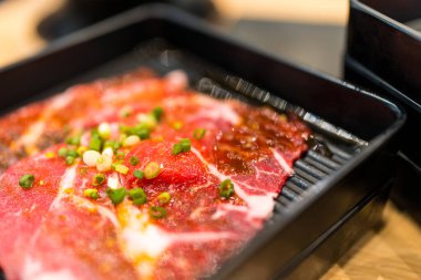 Taze çiğ et, taze ve sağlıklı yemek malzemesi pişirmek için siyah tepside ince ince dilimlenmiş.