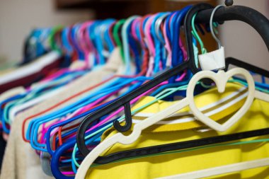 Evdeki korkuluklara giysi asılmış plastik askılar. İndirim, takas, bağış