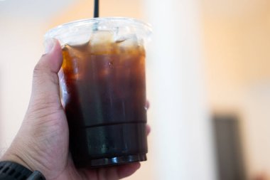 Plastik bardaktaki buzlu, sade kahvenin yakın çekimi.