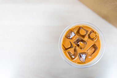 Bir bardak buzlu Thai sütlü çay ve yüzen buz küpleri.