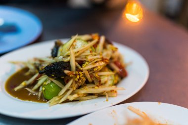 Yengeç ve mayalanmış balıklı bir tabak papaya salatası.
