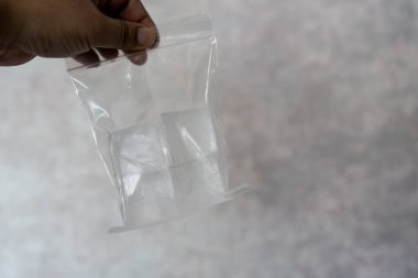 Buz küpleri insan eli üzerinde şeffaf bir plastik torba içinde