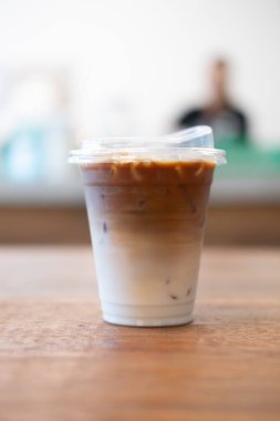 Eve, ahşap sehpanın üzerinde buzlu kahve götür.