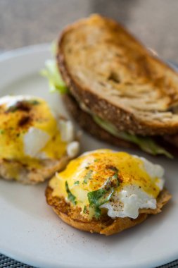 Lezzetli bir tabak yumurta Benedict beyaz bir tabakta