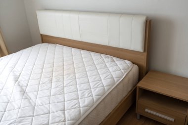 Yeni beyaz yatak, boş odada çarşaf yok.