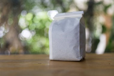 Beyaz kahve ambalajı. Ahşap masa üzerinde, doğaya aykırı kahve.