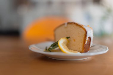 Lezzetli limonlu kek dilimi, yumuşak ve kabarık, keskin limon jöleli ve bir tutam naneli..