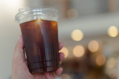 Erkekler ellerinde plastik bardak sade kahve tutarlar.