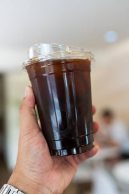 Biri içmeden önce plastik bir bardak Americano tutsun..