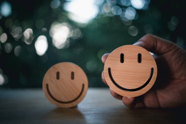 Deneyimli araştırma hizmetleri ve ürün inceleme konsepti için gülen yüz simgelerine sahip tahta etiket. Müşteri veya İstemci İyi Nötr veya Olumsuz geri bildirim ve memnuniyet derecesi göster.