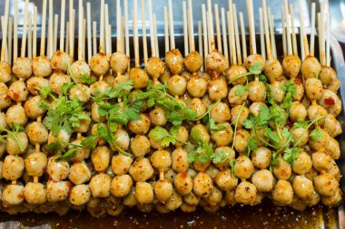 Grilled pork balls with spicy dipping chili sauce toping with coriander.  Popular appetizers side dish roasted meat balls.