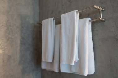 Clean white towel hanging on modern chrome bar in hotel
