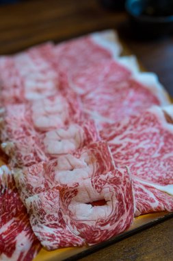 Dilimlenmiş Wagyu bifteği Sukiyaki ya da Shabu Shabu için düzgün bir tepside dizilmiş.