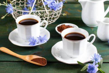 Sıcak doğal hindiba kafeini, ahşap bir masada bir bardakta bedava içki. Kahve ve kafein için sağlıklı bir alternatif. Mavi hindiba çiçeği