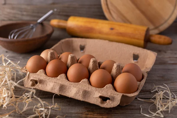 Eggs in a cardboard box on a wooden table, close-up.