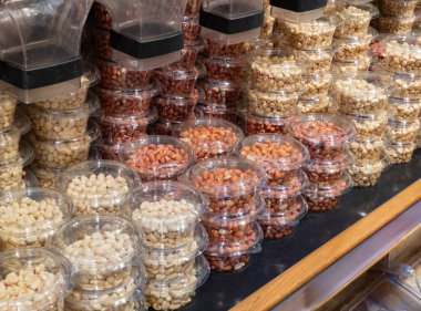 Süpermarketteki rafta kurumuş fındık var. Marketlerde yeniden kullanılabilir yiyecek dağıtıcılarında sergilenen tohum ve fındık çeşitleri. Organik dükkanda içi kuru yiyeceklerle dolu raflar. Yakın plan..