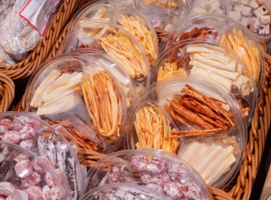 Çeşitli peynir, sosis ve jambon çeşitleri dükkan veya market raflarında. Geleneksel İtalyan aperatifleriyle alışveriş. Yakın plan..