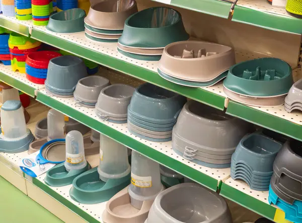 Bowls on shelves in pet shop. Choosing the bowl in pet store. Market shelves with supplies and accessories dogs and cats.