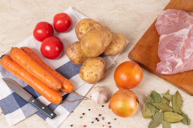 Mutfaktaki masada çiğ malzemeler, etli haşlanmış patates. Et, patates, havuç, maydanoz, sarımsak, domuz eti çorbası. Multi Coker 'da yemek pişirmek. Yakın plan..