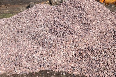 Crushed stone mound. Red crushed stones. Close up. Versatile building material for horticulture, landscape gardening or road construction. Material for railroad construction. clipart