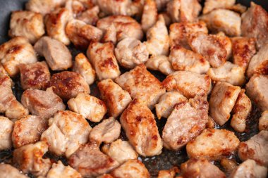 Kızarmış sulu küçük dilimlenmiş biftek, domuz veya tavada tavuk. Kızarmış biftek ya da tavada domuz eti. Mutfakta yemek pişirmek. Yakın plan..