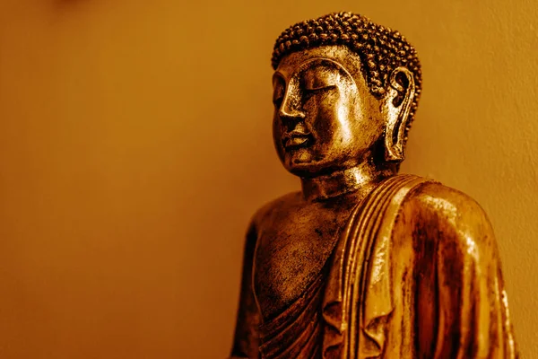 壁の背景に座って瞑想のポーズで黄金の仏像の肖像画 智慧と清浄の仏教宗教シンボル — ストック写真