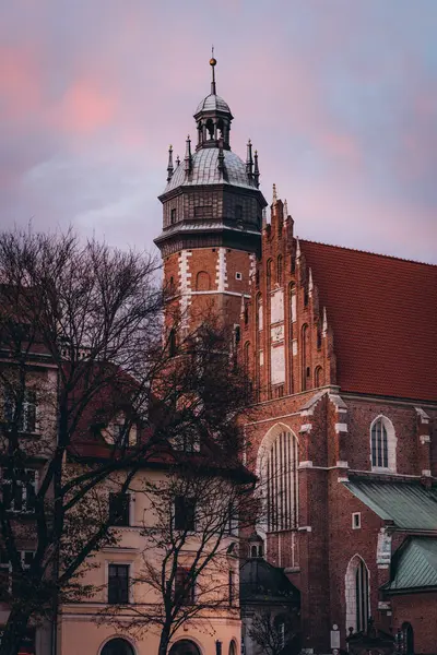 Cityscape at sunset, old Corpus Christi Basilica and vintage buildings in Krakow, Poland