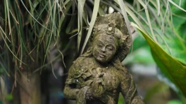 Yeşil doğa geçmişi olan bale heykelinin yakın çekimi. Hinduizm din heykeli, bali mimarisi