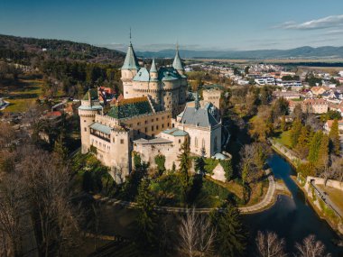 Slovakya 'daki Bojnice Kalesi' nin havadan panoramik görüntüsü. Kuşların bakış açısı, tarihi anıt, antik krallar sarayı ve şehrin orman ağaçları ve binaları arasındaki tepe üzerindeki kale.
