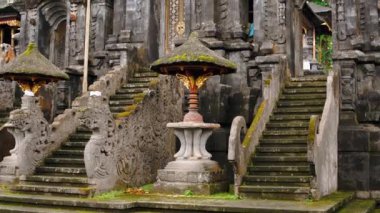 Karmaşık oymalar ve taş heykellerle dolu geleneksel bir Bali tapınağının ayrıntılı giriş kapısı. Bali 'nin zengin kültürel ve mimari mirasını yansıtıyor..