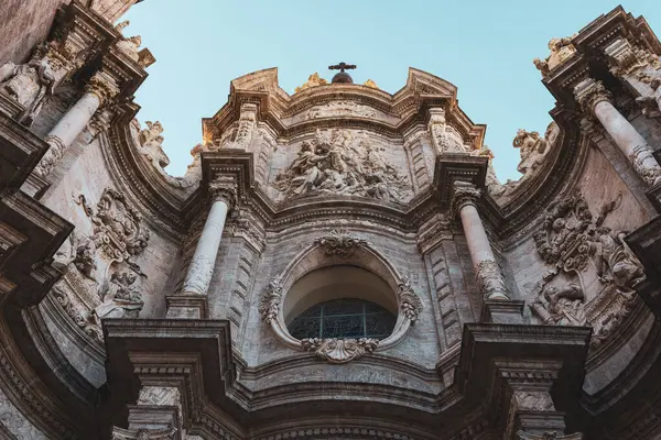 Valencia Katedrali 'nin süslü görünüşü, karmaşık oymalar ve mimari detaylarla dolu. Tarihi yapı berrak bir gökyüzüne karşı duruyor, ihtişamını sergiliyor..