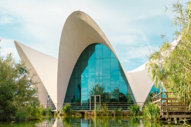 Çağdaş mimarinin çarpıcı bir örneği süpürme eğrileri ve yansıtıcı camlar içeriyor. Bina yemyeşil ve dingin bir suyla çevrili. Estetik cazibesini arttırıyor..
