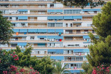 İspanya 'nın Alicante şehrinde yeşil ve ağaçlarla çevrili mavi çizgili tentelerle süslenmiş büyük bir yerleşim yeri huzurlu bir şehir ortamı yaratıyor..