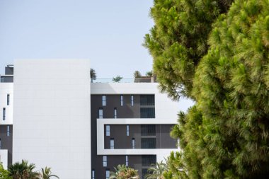 İspanya 'nın Alicante şehrinde modern bir yerleşim yeri. Parlak mimari tasarımı var. Ağaçlarla kısmen gizlenmiş..