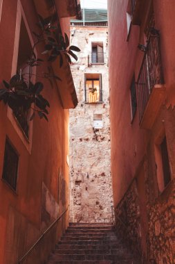 Sıcak tonlarda kırsal binalarla dolu büyüleyici bir ara sokak Tarragona, İspanya 'daki gizli hazinelerini keşfetmeye davet ediyor.