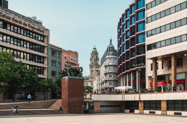 Porto 'daki canlı şehir meydanında modern binalar, tarihi mimari ve şehir keşfi için ideal bir at heykeli bulunuyor. Porto, Portekiz - 11 Haziran 2025