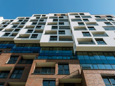 Açık mavi gökyüzü altında tuğla, cam ve beyaz elementlerin yer aldığı çağdaş konut mimarisi, Güney İspanya 'da gayrimenkul, kentsel yaşam ve emlak yatırımları için ideal.