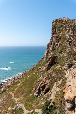 Engebeli arazisi ve mavi Atlantik Okyanusu üzerindeki vahşi bitki örtüsüyle sarp kayalıklar Lizbon kıyı manzarasının doğal güzelliğini ve macerasını yakalıyor..