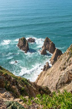 Cabo da Roca, Lizbon 'daki Atlantik Okyanusu' ndan yükselen engebeli kayalıkların ve keskin kaya oluşumlarının çarpıcı görüntüsü seyahat, doğa ve manzara için mükemmel..