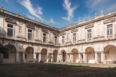Eski bir Lizbon manastırının zarif avlusunda kemerli yürüyüş yolları, yıpranmış taşlar ve klasik mimari, tarih, seyahat ve kültürel miras görselleri için ideal..