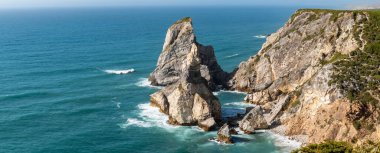 Cabo da Roca engebeli uçurumlarının ve Lizbon yakınlarındaki Atlantik Okyanusu dalgalarının çarpıcı panoramik manzarası, web ve editör kullanımında seyahat, doğa ve macera temaları için mükemmel.