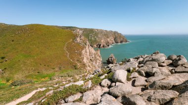 Engebeli uçurumların ve kayalık kıyı şeridinin Lizbon yakınlarında mavi Atlantik Okyanusu 'yla buluşmasının çarpıcı görüntüsü, seyahat, doğa ve macera ilhamı veya web sitesi geçmişi için mükemmel.