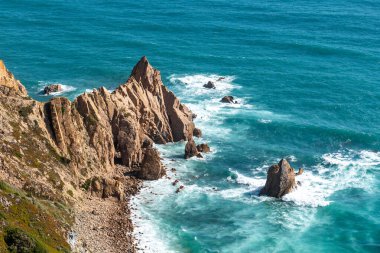 Çarpıcı sarp kayalıklar ve turkuaz dalgalar Lizbon kıyı şeridi boyunca çarpışıyor. Seyahat ilham kaynağı, doğa geçmişi veya Portekiz turizmi için mükemmel..
