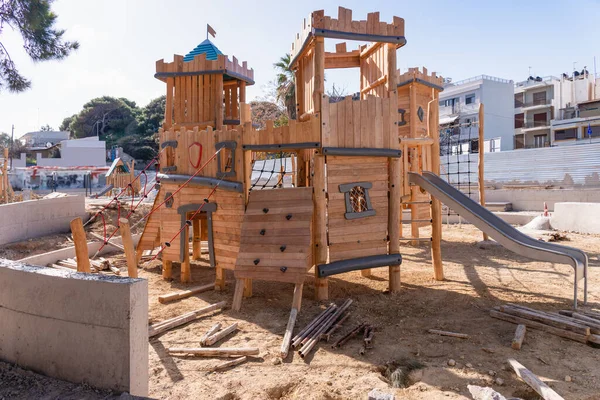 Building a new wooden playground recreation area for children at public park. Construction site works to build a safe wooden recreational playground for young children at public park