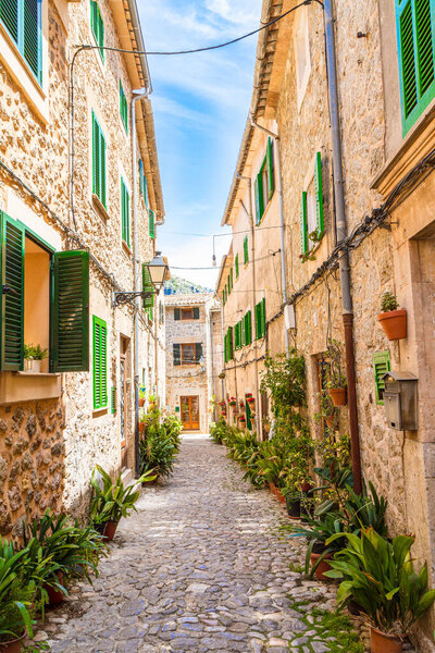 Pebble stone paved old narrow street, with stone built houses, in Valdemossa medieval village, Mallorca, Balearic Islands, Spain