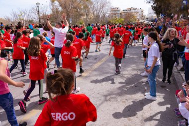 HERAKLION, CRETE, GREECE, 2 NİSAN 2023. Yunanistan Heraklion Girit 'te düzenlenen yıllık Run Greece 1 km kentsel karayolu yarışında koşan genç okul çocukları atletler.