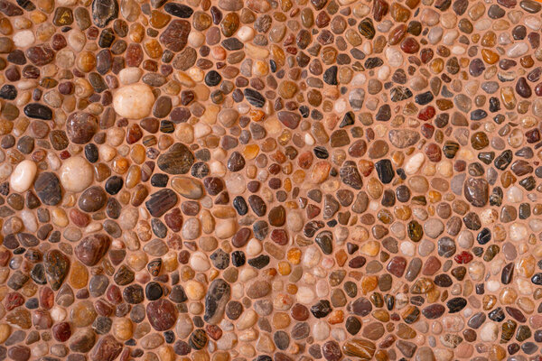 Polished beige warm colors pebble stone seamless wall decoration texture. Sea floor gravel pebble stone wall decoration