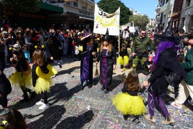 Heraklion, Girit, Yunanistan - 10 Mart 2024: Heraklion Girit 'te Mardi Gras geçit töreni. Renkli kostümlü maskeli karnaval katılımcıları Heraklion 'un kalabalık ana caddesinde geçit töreni yapıyorlar.
