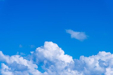Kümülüs fırtınası bulutlarının eşsiz gövdeleri mavi gökyüzü arka planında