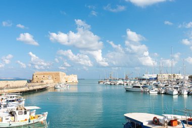 Akdeniz şehri Heraklion tarihi Venedik limanı silüeti manzarası. Ünlü liman limanına demirlemiş balıkçı tekneleri ve lüks yatlar. Girit Seyahati, Yunanistan